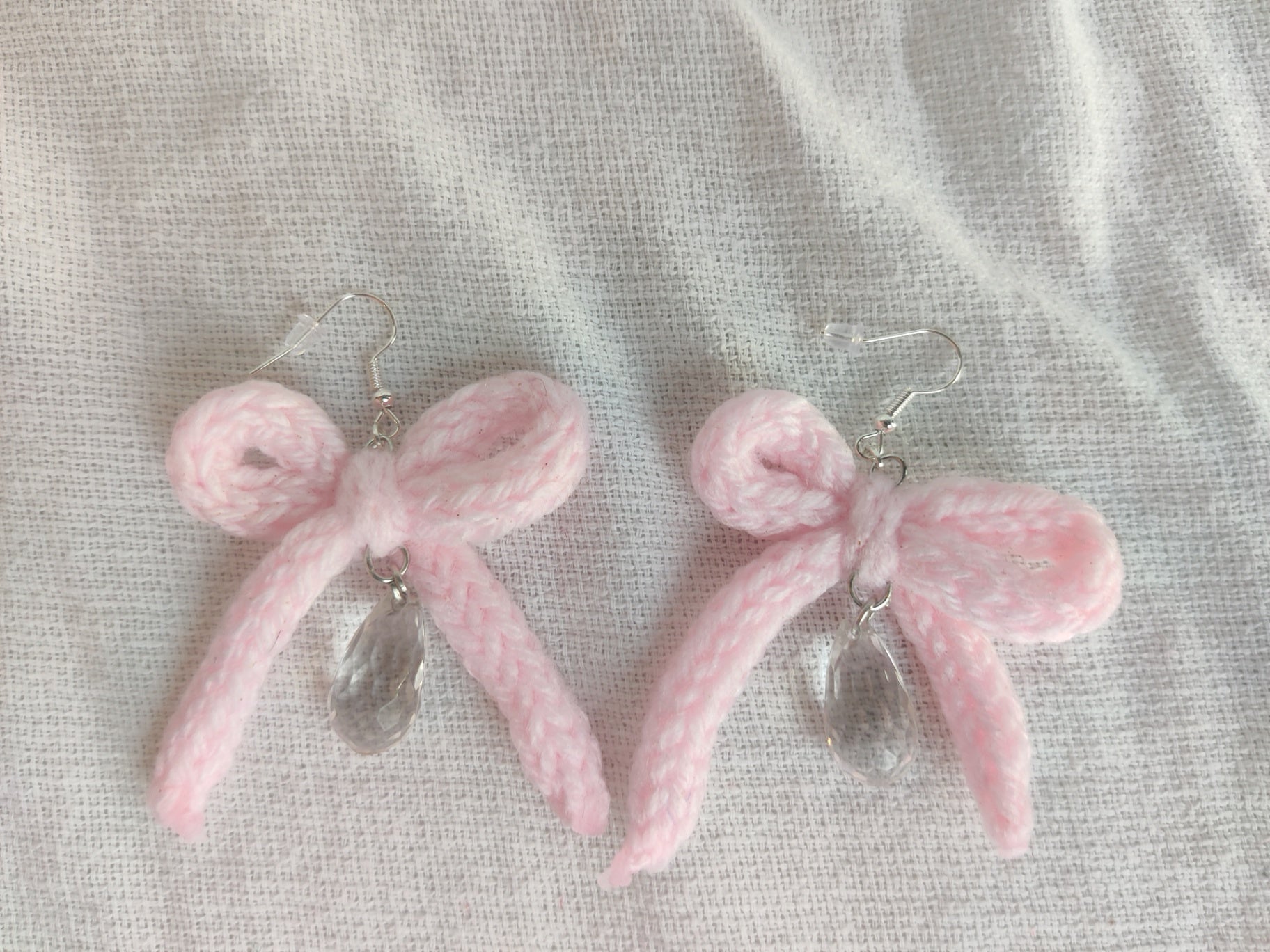 Crochet light pink bow earrings with raindrop bead charm