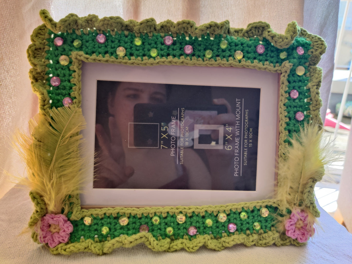 Crochet green photo frame wit feathers